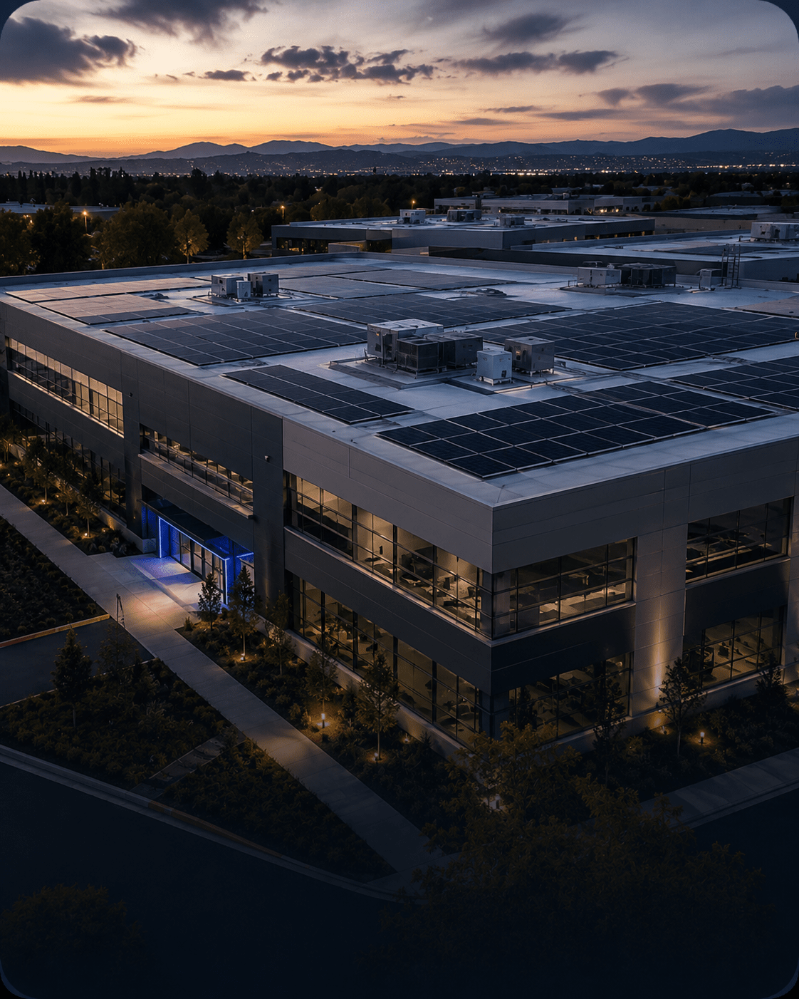 Large commercial building with a rooftop solar panel system at sunset